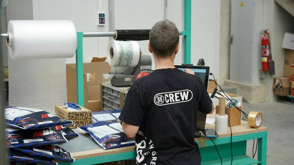 Operator wykonujący ręczne pakowanie zbiorcze w małym zakładzie produkcyjnym